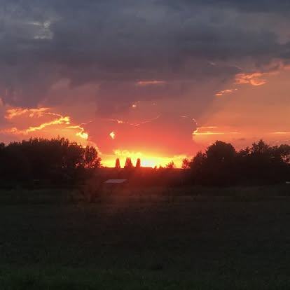 Zonsondergang boven een open landschap
